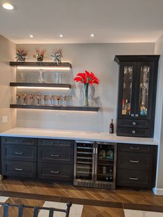 an empty bar with wine glasses and bottles on the top shelf in a home kitchen