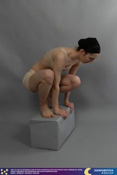 a statue of a woman kneeling on top of a block