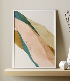 a framed art print on a shelf next to a vase with dried flowers in it