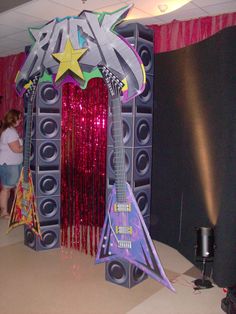 two people standing in front of a stage set up for a party with guitars and sound equipment