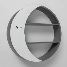 a circular shelf with a face drawn on the side and shelves in the shape of a crescent