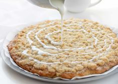 a person pouring cream on top of a cake