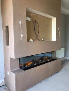 a room with a fire place in the middle and some wires hanging from the wall