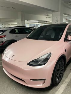 a pink tesla parked in a parking garage