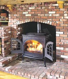 a wood burning stove in a brick fireplace