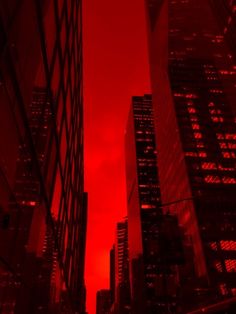 the sky is red and there are skyscrapers in the background