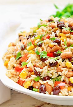 a white bowl filled with rice, beans and veggies on top of a table