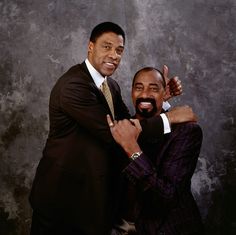 two men in suits and ties posing for a photo with their arms around each other