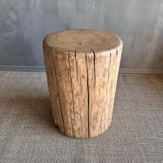 a wooden stool sitting on top of a carpeted floor