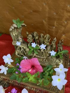 a vase with flowers in it sitting on top of a table next to an elephant figurine