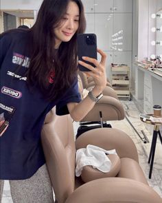 a woman taking a selfie with her cell phone in a hairdressing room