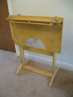 a wooden table with a hole in the middle and a door behind it, on carpeted flooring