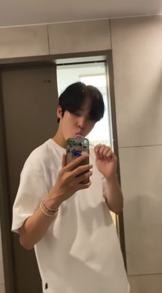 a man taking a selfie in front of a mirror while holding a cell phone