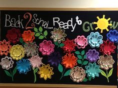 a bulletin board with paper flowers and the words back 2 sun ready to grow on it