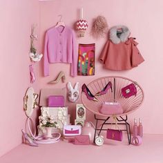 a pink room with clothes and accessories on the wall