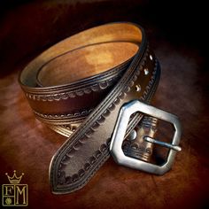 "This brown leather belt starts as a hide of 9 oz. High quality vegetable tanned leather. It is hand cut to 1-3/4\" and hand stamped with a Classic western border. It's dyed in a vintage dirty dark brown. It has smooth finished edges right down to a tapered english point. The entire belt is then waxed and polished to a beautiful sheen! A hand aged classic clipped corner centerbar buckle closes it up and 2 aged snaps allow the buckle to be changed! Completely handmade and available in black! I ne Tooled Belt, Rhinestone Belt Buckle, Leather Tool Belt, Custom Leather Belts, Western Bling, Cowgirl Belts, Bling Belts, Tooled Leather Belts, Stamped Leather