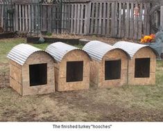 three dog houses made out of wood in the yard