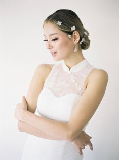 a woman in a white dress with her arms crossed