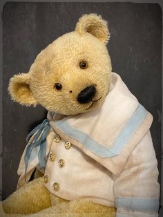 a teddy bear dressed in white and blue