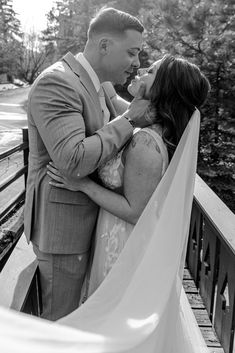 a man and woman standing next to each other on a bridge