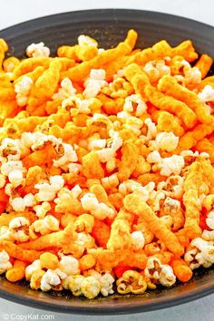 a bowl filled with popcorn kernels on top of a table