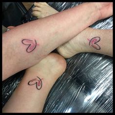 two people with tattoos on their legs sitting next to each other