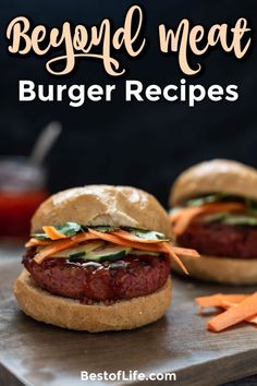 two burgers with lettuce, carrots and meat sitting on a cutting board