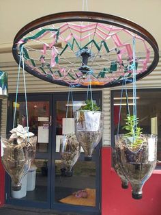 some plants are hanging from the ceiling in front of a store