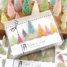 a box filled with different colored trees next to some candy canes on top of a table