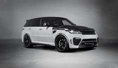 a white range rover parked in front of a gray background with black rims and wheels