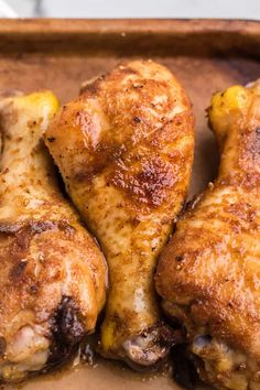 three pieces of chicken sitting on top of a pan