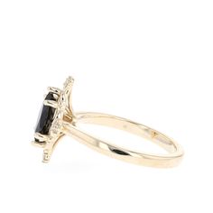 a yellow gold ring with an oval cut black diamond and two smaller diamonds on the side