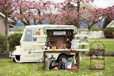 an ice cream truck is parked in the grass with flowers on it's side