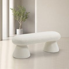 a white bench sitting next to a potted plant on top of a table in a room