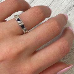 a woman's hand with a diamond and sapphire ring