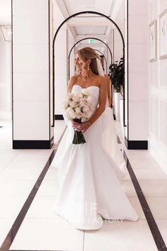 a woman in a white wedding dress holding a bouquet