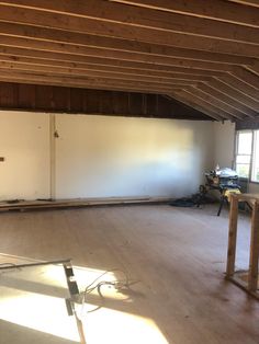 an empty room with unfinished walls and wood floors