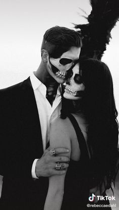 a man and woman in skeleton makeup hugging each other