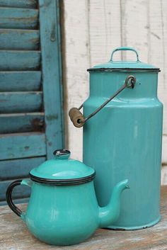 two tea kettles sitting next to each other on a table