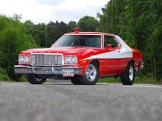 a red and white car driving down the road