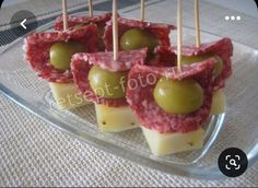 small appetizers with olives and cheese are on a glass plate, ready to be eaten