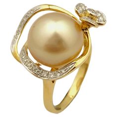 This elegant ring features a stunning 12.6mm golden South Sea pearl, known for its exceptional luster and rich, warm hue. The pearl is beautifully accented by 0.18 carats of sparkling diamonds, meticulously set in a graceful design that enhances its natural beauty. Crafted from 18-karat yellow gold, the ring provides a luxurious backdrop that perfectly complements the golden pearl and diamonds. The design includes delicate diamond accents that form a floral motif, adding an extra touch of sophis Luxury Yellow Gold Pearl Ring With Single Diamond, Luxury Delicate Yellow Gold Pearl Ring, Pearl Diamond Ring, Pearl Cocktail Ring, Golden Pearl, Golden South Sea Pearls, Pearl And Diamond Ring, Sea Pearl, Modern Ring