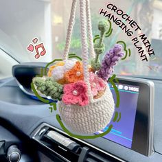 a crochet hanging planter in the dashboard of a car with music notes