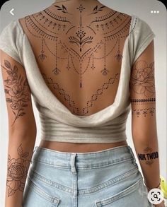 the back of a woman's body with tattoos on it