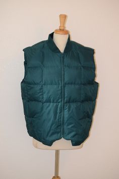 "Great piece for layering, retro style. Forest green down vest by 'Fieldmaster' was made in Korea and sports large front angled patch pockets, large stitched square goose down filled baffles and roomy oversize styling.  Tone on tone chunky nylon YKK zipper.   Looks unworn and is free of rips, stains and odor. Marked a vintage extra large / fits like a large / check measurements carefully Back of ribbed neck to bottom of vest:  29\" Shoulder to shoulder at back:  20\" Armpit to armpit:  26\" Under arm seam:  13\" Side to side at bottom:  24 1/2\" Zipper:  21\" For a variety of vintage goodies, check out my shop @: https://www.etsy.com/shop/RagandBonesFinds For a unique pillow fashioned from my treasure trove of vintage fabrics, visit my shop @: https://www.etsy.com/shop/VintagePulledThreads Camping Vest, Hiking Vest, Navy Blue Vest, Festival Boots, Unique Pillow, Summer Shorts Denim, Pet Tiger, Puffy Vest, Boho Sweater