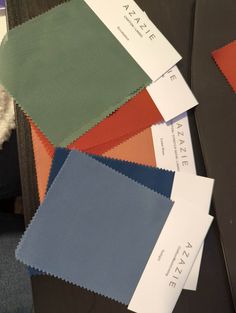 several different colors of fabric sitting next to each other on top of a black table