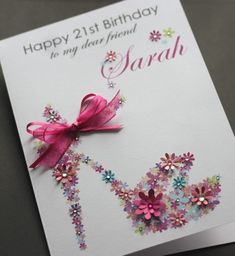 a happy 21st birthday card with flowers and a pink bow on it's side