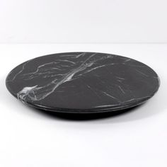 a black marble plate sitting on top of a white table