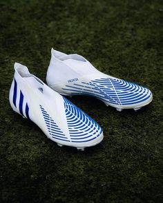 a pair of white and blue soccer shoes