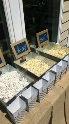 three trays filled with popcorn sitting on top of a table next to each other